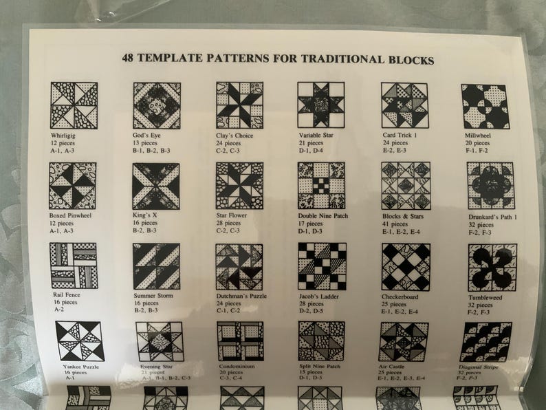以下が含まれることがあります： 48 TEMPLATE PATTERNS FOR TRADITIONAL BLOCKSというタイトルの白い説明シート。白黒のキルトブロックパターンのグリッドが並んでいます。各正方形には、名前、ピース数、および対応するテンプレートのコードが記載されています。