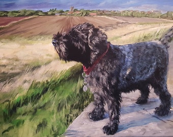 May include: A black dog with a red collar and a silver tag stands on a stone path looking out at a field of brown and green grass. The dog is in the foreground of the painting, with a distant village in the background.