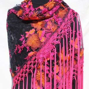 May include: A black sheer shawl with pink and orange floral embroidery and pink fringe.