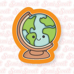 May include: A cookie cutter in the shape of a smiling globe. The globe features green continents and blue oceans, set within a brown stand and frame. The cutter has an orange outline.