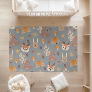 May include: A blue and brown patterned rug with a repeating design of deer, foxes, rabbits, mushrooms, and stars. The rug is perfect for a nursery or playroom.
