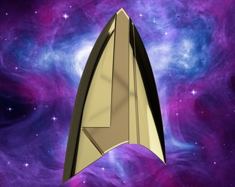 Puede incluir: Un emblema de la Flota Estelar de color dorado, una forma delta estilizada, sobre un fondo de nebulosa púrpura y azul.