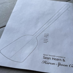 Puede incluir: Una plantilla de cuchara en blanco y negro impresa en papel. La plantilla mide 29,2 cm de largo y 6 cm de ancho. El texto en la imagen dice "Spoon Template provided by Sean Hearn & Huron Spoon Co."