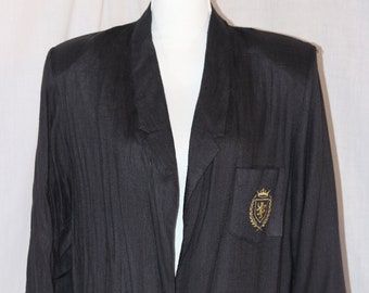 May include: A black blazer with a single button closure and a gold embroidered crest on the left pocket.