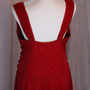 May include: A red sleeveless dress with a deep V-back and a flowing skirt.