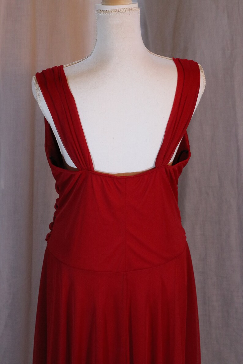 May include: A red sleeveless dress with a deep V-back and a flowing skirt.