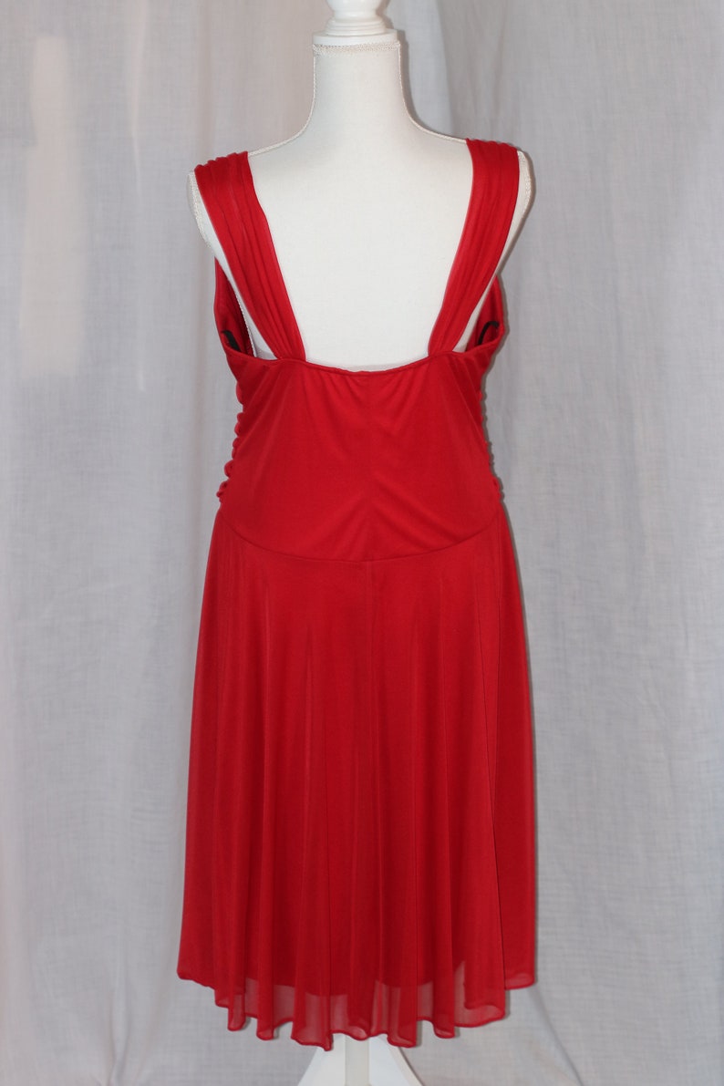May include: A red sleeveless dress with a low back and a flowing skirt.