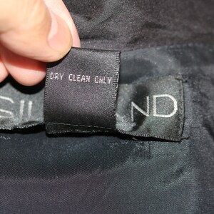 May include: Black care label with white text that reads "Dry Clean Only".