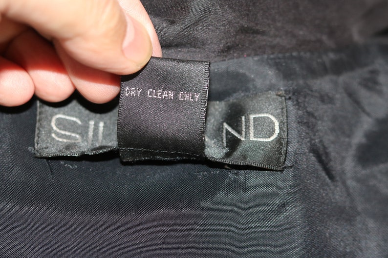 May include: Black care label with white text that reads "Dry Clean Only".