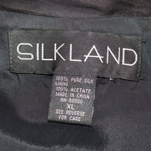 May include: Black tag with white text that reads "SILKLAND" and details about the fabric composition: 100% pure silk, lining 100% acetate, made in China, RN 88820, XL, see reverse for care.