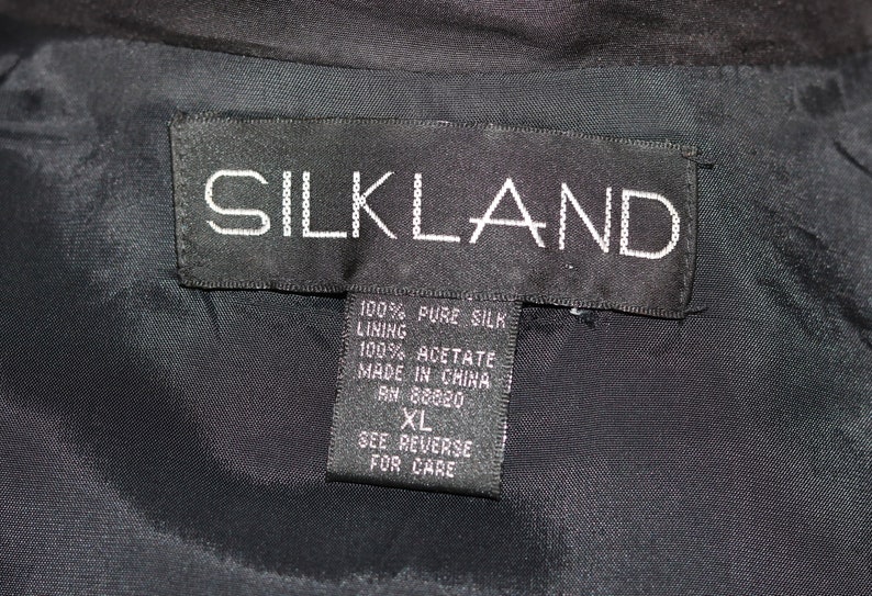 May include: Black tag with white text that reads "SILKLAND" and details about the fabric composition: 100% pure silk, lining 100% acetate, made in China, RN 88820, XL, see reverse for care.