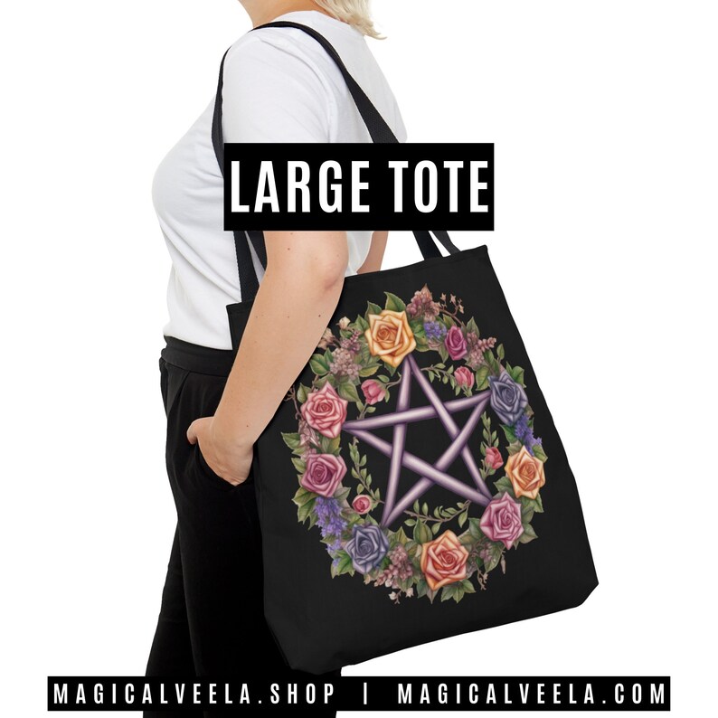 Puede incluir: Una bolsa de tela negra con un gran dise&ntilde;o de pentagrama floral. El pentagrama est&aacute; rodeado por una corona de rosas de colores y otras flores. El texto "LARGE TOTE" est&aacute; impreso en blanco en la bolsa.