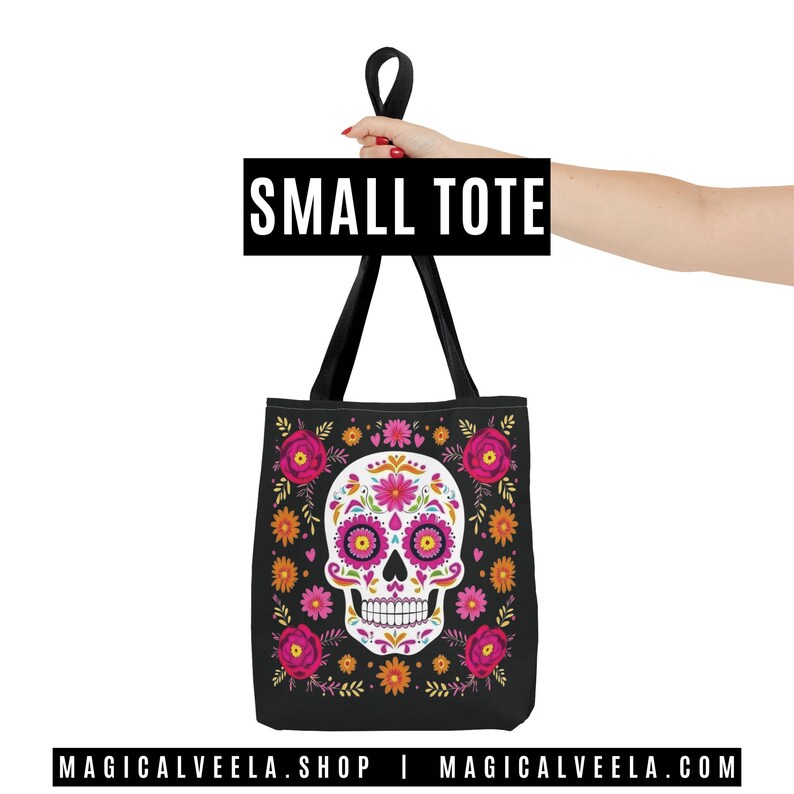 May include: Black small tote bag featuring a sugar skull design with pink, orange, and yellow floral accents. The skull has pink and purple details. The bag has black handles and the text "SMALL TOTE". The website address is also visible.