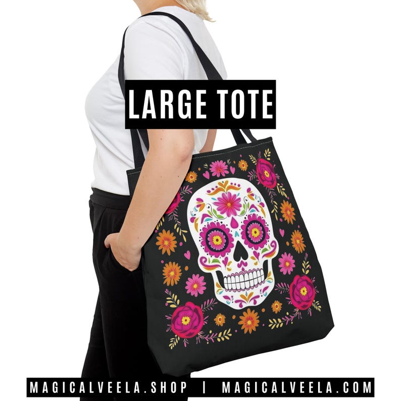 May include: Black tote bag featuring a colorful sugar skull design with pink, orange, and yellow floral accents. The bag has a large capacity and the text "LARGE TOTE" is displayed at the top. The website address "MAGICALVEELA.SHOP" is at the bottom.