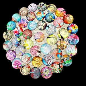 May include: A collection of round glass cabochons, each featuring a unique tree design. The cabochons display a variety of colors, including blue, pink, yellow, and orange, with intricate tree patterns. The cabochons are arranged on a light-colored surface.