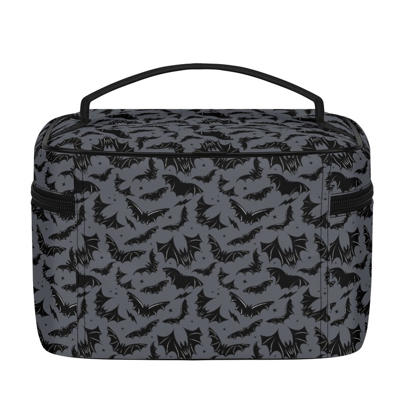 May include: A gray and black toiletry bag with a bat pattern. The bag has a black zipper and a black handle.