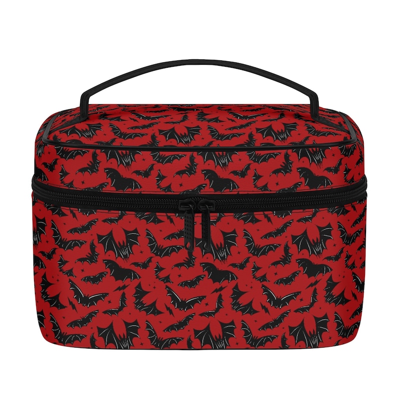 May include: Red travel makeup bag with a black zipper and a black bat pattern.