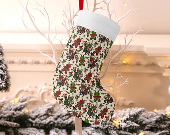 May include: Christmas stocking with a white cuff and red hanging loop. The stocking features a repeating pattern of green and red gingerbread men, candy canes, and other holiday-themed elements on a cream background.