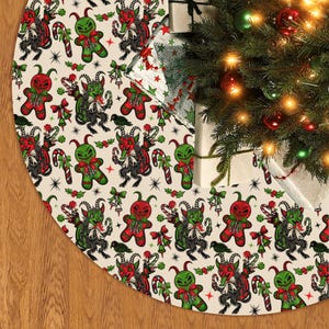 May include: A cream-colored Christmas tree skirt with a repeating pattern of red and green gingerbread-like demons, candy canes, and bows. The skirt is circular and sits beneath a decorated Christmas tree with ornaments and lights.