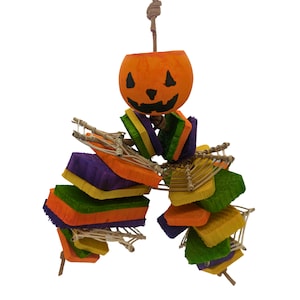 May include: A Halloween-themed bird toy with a carved pumpkin, colorful wooden blocks, and a woven rope. The toy is designed for small birds to chew and play with.