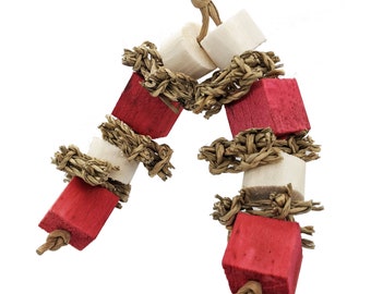 May include: A hanging pet toy featuring two strands of natural fiber rope knotted at the ends. The strands are threaded with alternating red-dyed wooden cubes and natural white wooden blocks, separated by woven seagrass rings.