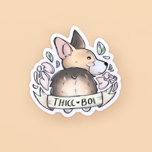 May include: A white sticker with a cartoon illustration of a corgi dog with a brown and black coat. The dog is facing away from the viewer and has a heart-shaped tail. The sticker has a banner with the text "THICC BOI" and floral designs around the dog.
