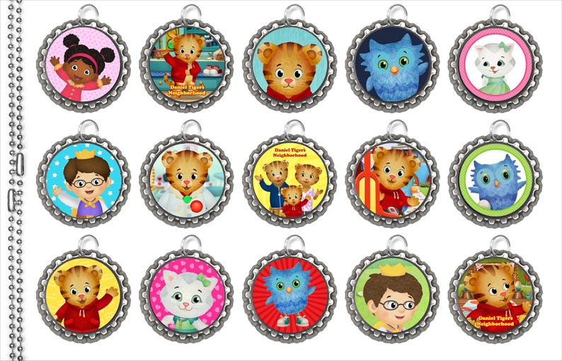 Peut inclure: Une collection de quinze pendentifs circulaires repr&eacute;sentant les personnages de la s&eacute;rie pour enfants "Daniel Tiger's Neighborhood". Chaque pendentif a un bord festonn&eacute; argent&eacute; et une petite boucle pour l'accrocher. Les pendentifs affichent divers personnages aux couleurs vives.