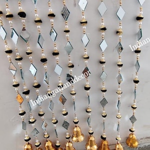 Può includere: Ghirlanda decorativa con forme a diamante specchiate, pompon neri e perline dorate. La ghirlanda è adornata con piccole campane dorate. Adatta per occasioni festive.