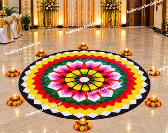 May include: A circular rangoli floor art design featuring a vibrant geometric pattern in yellow, red, green, pink, and white, surrounded by several small brass oil lamps placed on circular marigold flower garlands on the floor.
