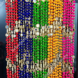 Puede incluir: Cinco hileras de adornos para puertas con pompones de colores y espejos redondos. Las hileras son roja, azul, verde, amarilla y rosa.