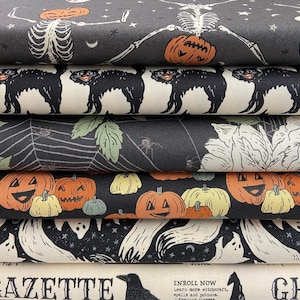 Può includere: Una pila di rotoli di tessuto a tema Halloween. I disegni includono scheletri con teste di zucca, gatti neri, ragnatele, lanterne, fantasmi e testo che dice "LY GAZETTE" e "ENROLL NOW". I colori includono nero, arancione, bianco e verde.