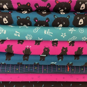 May include: Stack of eight fabric panels featuring a repeating pattern of black bears with musical notes and stars. The fabric is in a variety of colours, including pink, teal, and blue.