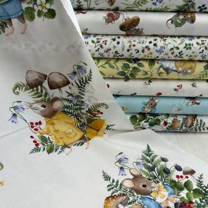 Peut inclure: Un tissu blanc avec un motif répétitif de souris illustrées portant des vêtements, entourées de champignons, de fougères, de campanules et de baies rouges. Le design inclut des souris en imperméables jaunes et tenues bleues, avec des rouleaux de tissu empilés.