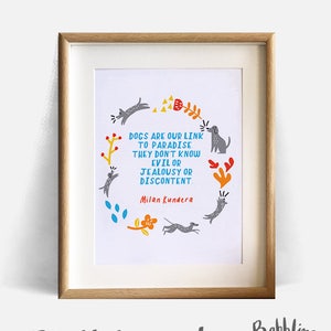May include: A digital print featuring a quote about dogs and paradise by Milan Kundera. The quote is surrounded by a circle of illustrated dogs and flowers. The print is framed in a light wood frame.