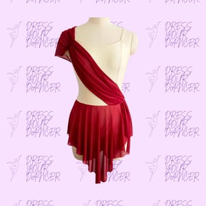 May include: A dance costume on a mannequin. The costume features a cream-colored bodice with a burgundy asymmetrical overlay and a matching skirt. The skirt has an asymmetrical hemline. The words "DRESS YOUR DANCER" are printed on the background.