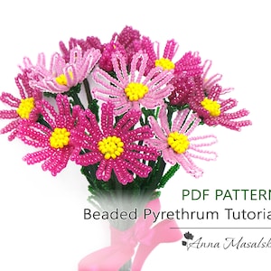 May include: A bouquet of pink and white beaded flowers with yellow centers. The flowers are arranged in a vase and tied with a pink ribbon. The text "PDF PATTERN Beaded Pyrethrum Tutorial" is printed below the flowers. The text "Anna Masalska" is printed below the tutorial title.