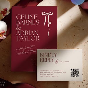 Könnte beinhalten: Burgunderfarbene Hochzeitseinladung mit weißem Text: "CELINE BARNES & ADRIAN TAYLOR" und einer Schleifenillustration. Eine kleinere Antwortkarte ist enthalten. Die Einladung enthält auch einen QR-Code und eine Website-Adresse.