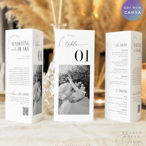 Puede incluir: Tres tarjetas de mesa de boda blancas con texto negro. Las tarjetas presentan los nombres "Madeline y Blake", números de mesa y una foto en blanco y negro de una pareja. Una tarjeta muestra el menú. Las tarjetas son para una boda.