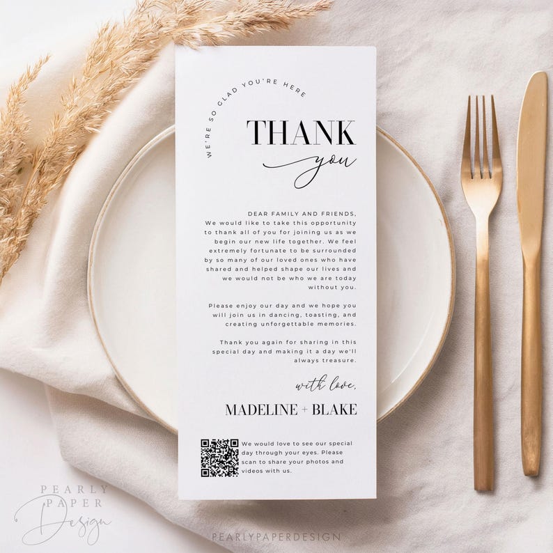 Op de afbeelding: Een witte bedankkaart met zwarte tekst. De kaart zegt "We're so glad you're here" in een cirkel bovenaan. De tekst "Thank you" staat in grote, vetgedrukte letters. De kaart bevat ook een bericht waarin de gasten worden bedankt voor hun aanwezigheid op de bruiloft en een QR-code om foto's en video's te delen.
