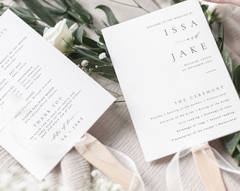 May include: Wedding ceremony program fans with white and black text. The fans feature the names "ISSA and JAKE" and the text "Welcome to the wedding of ISSA and JAKE". The fans also include the ceremony details, such as the seating of the mothers, entrance of the bride, and the exchange of vows.