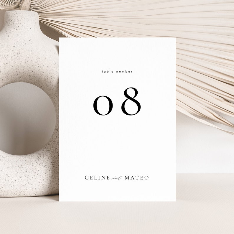 May include: White card with black text. The text reads "table number 08" and "CELINE and MATEO".