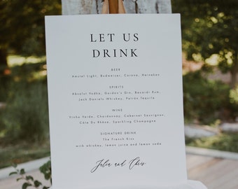 May include: A white sign with black text that reads "Let Us Drink" and lists a variety of beer, spirits, and wine options. The sign also includes a signature drink called "The French Kiss" with whiskey, lemon juice, and lemon soda. The bottom of the sign is signed "Julia and Chris".