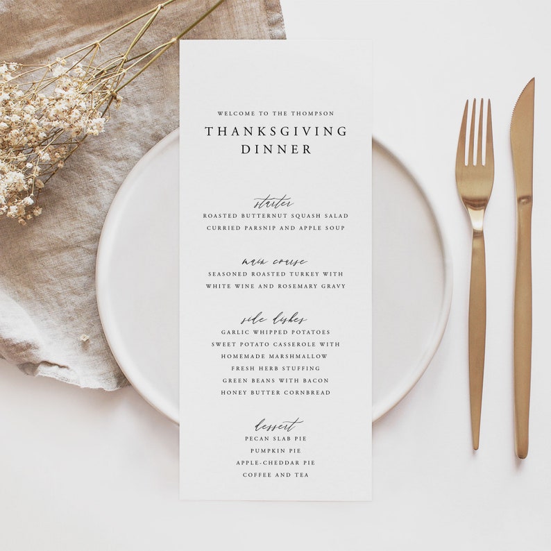 May include: A white card with a Thanksgiving dinner menu. The menu includes a starter, main course, side dishes, and dessert. The menu is written in a cursive font.