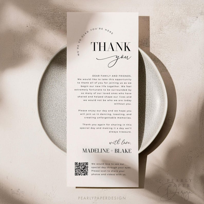 Op de afbeelding: Een bedankkaart met een eenvoudig zwart-wit ontwerp. De kaart bevat de tekst "Bedankt" in een handschrift en de woorden "Lieve familie en vrienden" in een sans-serif lettertype. De kaart bevat ook een QR-code en de tekst "We zouden graag onze speciale dag door jouw ogen zien. Scan om je foto's en video's met ons te delen."
