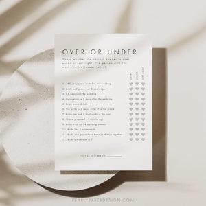 May include: A printable wedding game with the title "Over or Under" and a list of 12 questions about the bride and groom. Players guess if the answer is over, under, or just right. The game includes a section to tally the total correct answers.