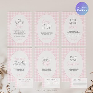 May include: A collection of baby shower game signs in pink and white gingham, featuring oval frames and elegant script. Games include "My Water Broke," "Baby Sock Hunt," and "Late Night Diaper." Includes matching game cards.