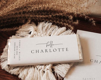 May include: White chocolate bar wrapper with the text "hello CHARLOTTE" and "EMMA + BLAKE 08.06.2022 CHOCOLATE 1.55 OZ".