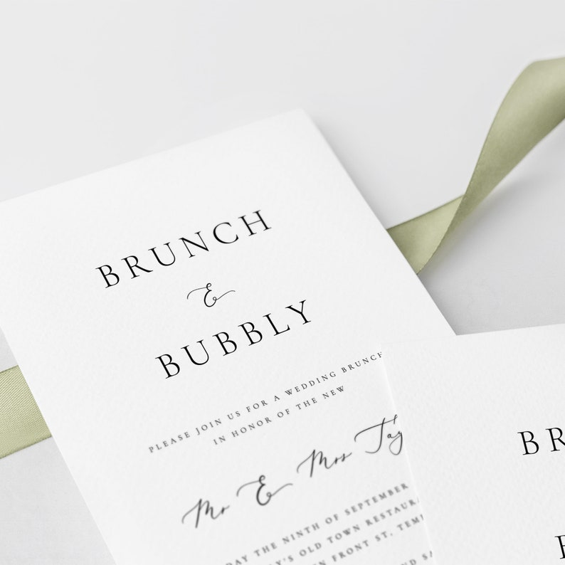 May include: A white wedding invitation with black text that reads "BRUNCH & BUBBLY" and "PLEASE JOIN US FOR A WEDDING BRUNCH IN HONOR OF THE NEW Mr & Mrs Ty". The invitation also includes the date "DAY THE NINTH OF SEPTEMBER" and the location "Y'S OLD TOWN RESTAURANT, FRONT ST, TEMI".