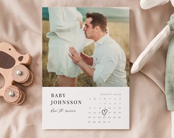 May include: A white calendar with a photo of a couple expecting a baby. The calendar is for the month of 2020 and has a heart drawn around the due date. The text "BABY JOHNSSON due to arrive" is printed on the calendar.