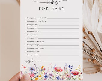 Può includere: Un biglietto bianco con il testo "wishes for baby" e un elenco di auguri per un neonato. Il biglietto è decorato con un'illustrazione ad acquerello di fiori selvatici colorati.